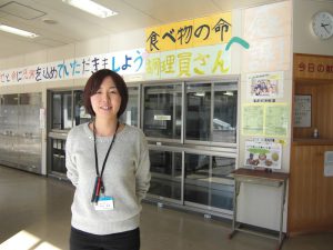 富士見町立富士見中学校栄養士畠山梨恵先生です。明るい給食室前で